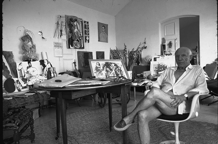 Pablo Picasso seated in Eero Saarinen's Tulip Chair, photograph by Gjon Mili