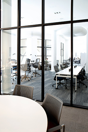 Civic Hall features a mix of open and enclosed workspaces and liberal use of glass to share the daylight that streams in from the huge windows. | Featured: ReGeneration by Knoll Work and High Task Chairs, Antenna Workspaces Tables, Sparrow Desktop Lights, MultiGeneration by Knoll Hybird Chairs