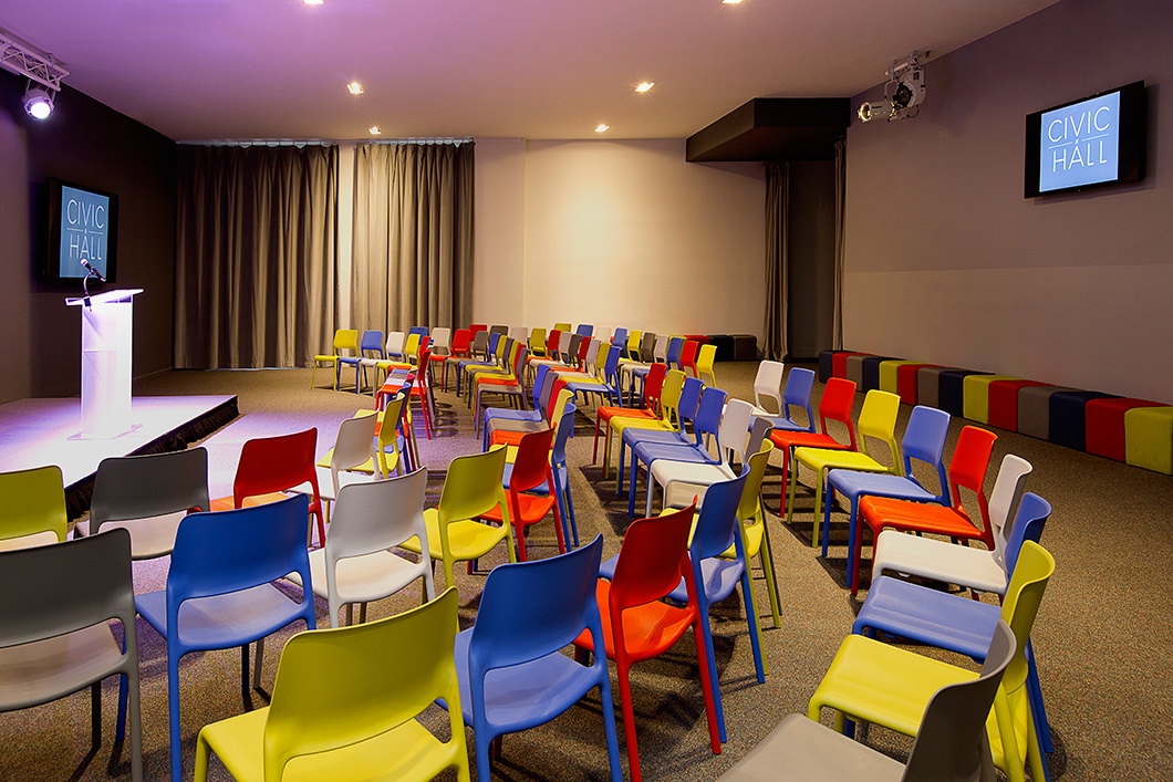 Lightweight stacking chairs and modular ottomans provide maximum flex for a multipurpose space that hosts lectures, receptions, workshops and movies on near-daily
regular basis. The bright palette adds a blast of energetic color. | Featured: Spark Series Side Chairs, k. lounge Stools